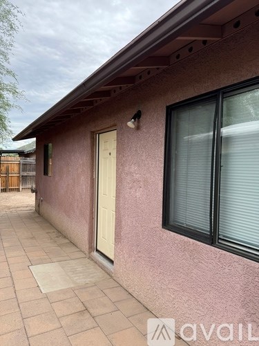 A house with a pink wall and a white door.