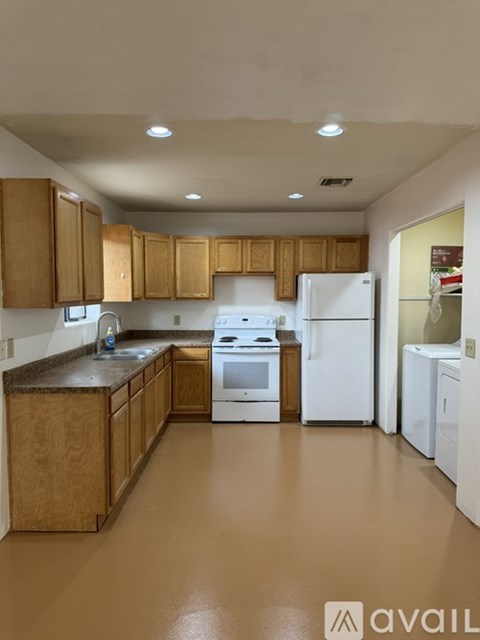 A kitchen with wooden cabinets and white appliances.