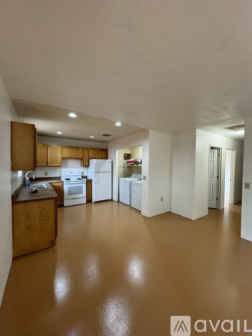 A kitchen with white appliances and wooden cabinets.