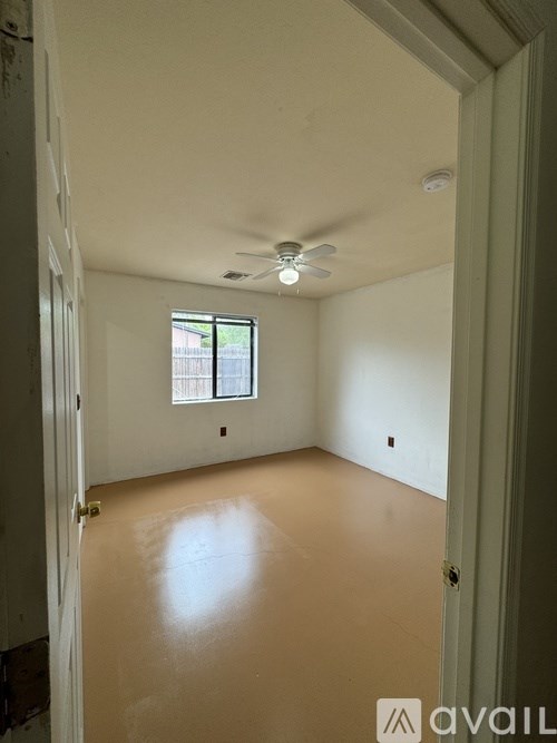 A room with a ceiling fan and a window.