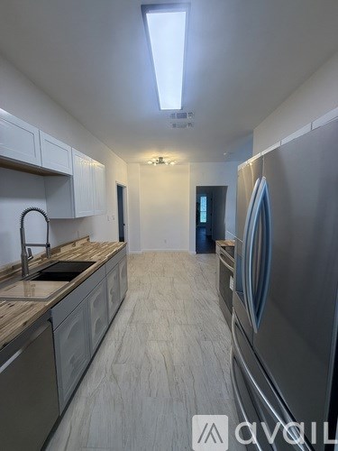 A modern kitchen with a refrigerator on the right side.