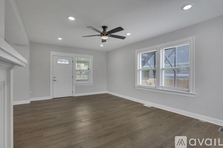 A wooden deck leads to a grey house with a satellite dish on the roof.