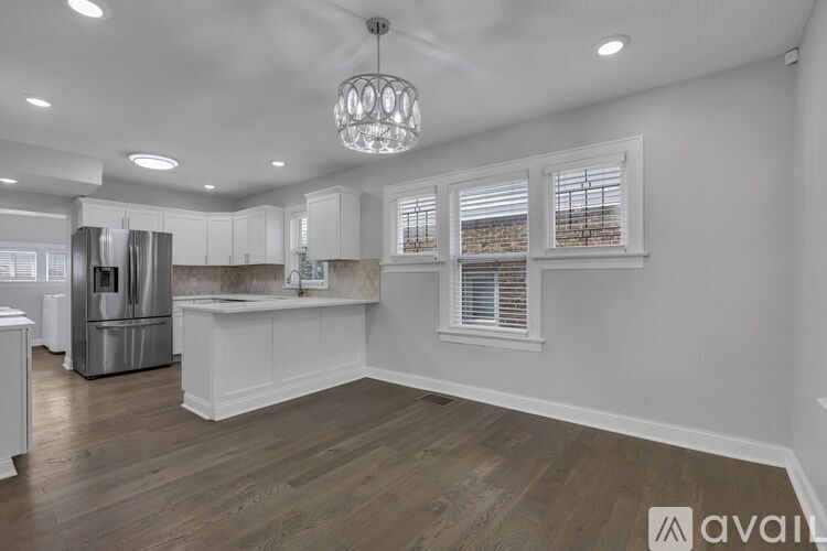 A modern kitchen with white cabinets and a stainless steel refrigerator.