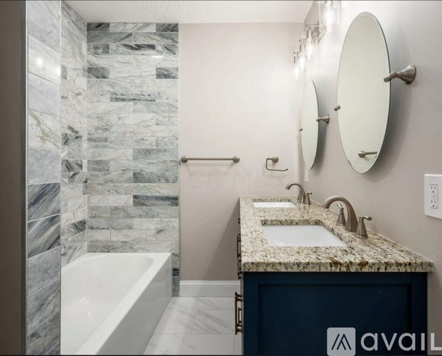 A bathroom with a marble tile shower and a sink with a granite countertop.