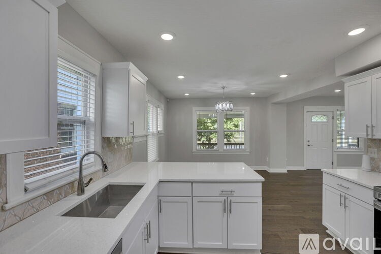 A modern kitchen with white cabinets and a marble countertop.