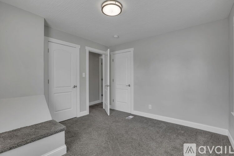 A room with a carpeted floor and a step leading to a door.