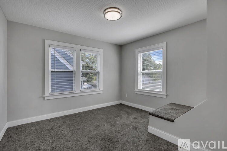 A room with two windows and a carpeted floor.