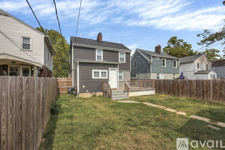 A house with a grey roof and a wooden fence in front of it.