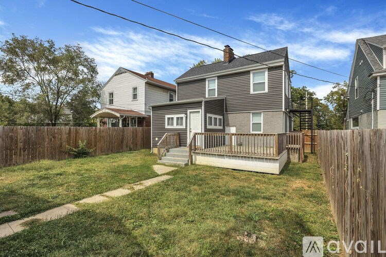 A house with a grey roof and a wooden fence in front of it.