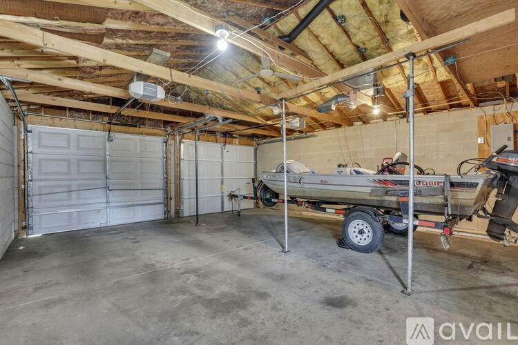 A large garage with a boat on a trailer inside.