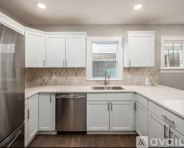 A kitchen with white cabinets and a stainless steel dishwasher.