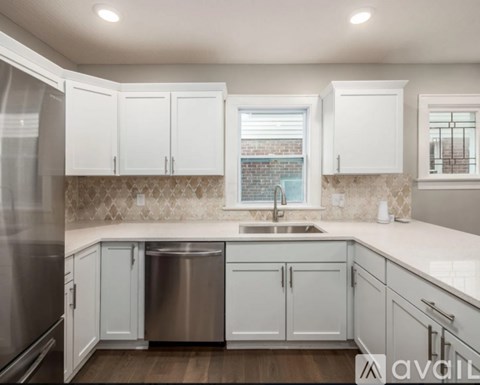A kitchen with white cabinets and a stainless steel dishwasher.