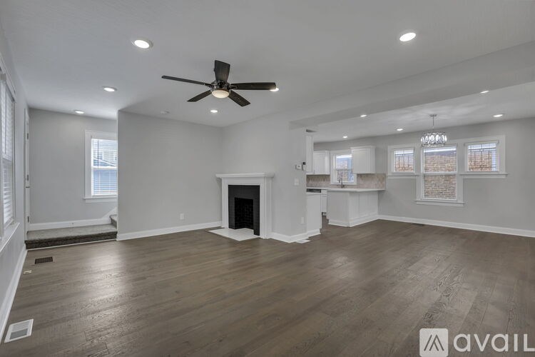 A spacious room with a carpeted floor and a window.