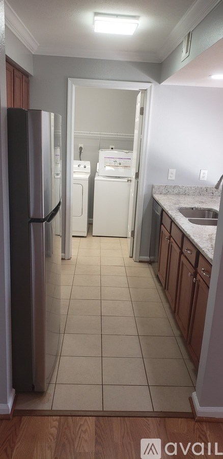 A kitchen with a black refrigerator and white dishwasher.