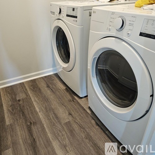Two white front load washing machines in a laundry room.