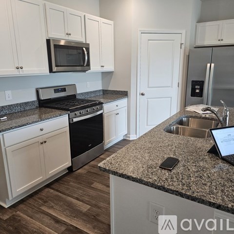 A kitchen with granite countertops and white cabinets.