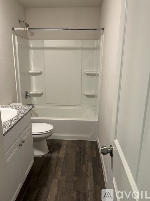 A small white bathroom with a toilet, sink and shower.