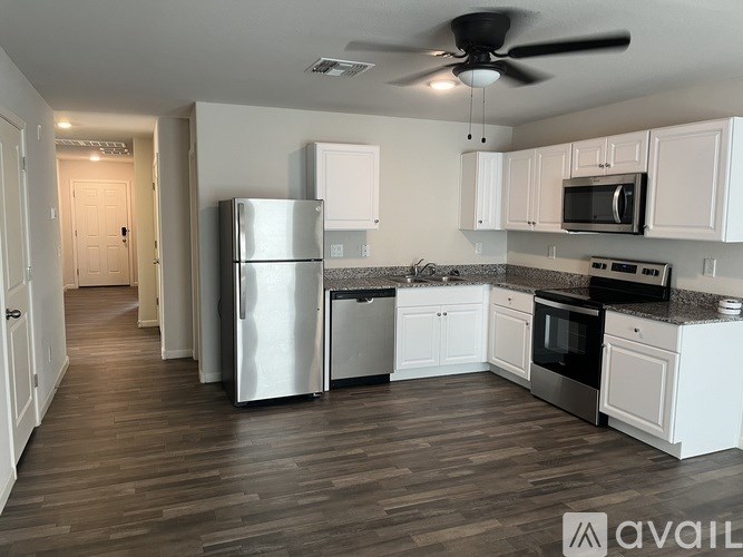 A kitchen with white cabinets and a refrigerator.