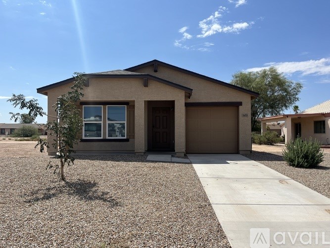 A house with a brown roof and tan walls is for sale.