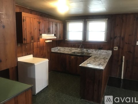 A kitchen with wooden cabinets and a marble countertop.