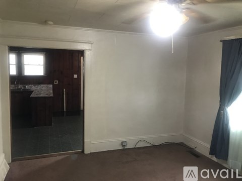 A room with a ceiling fan and a window.