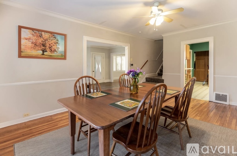 A dining room with a wooden table and chairs.