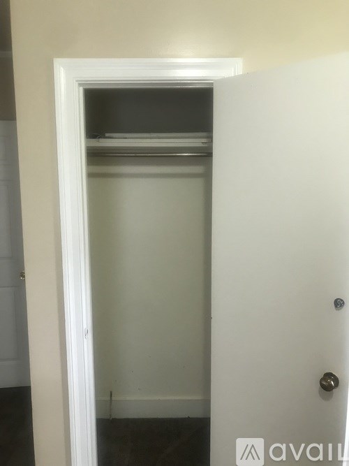 A white door with a silver handle is open.