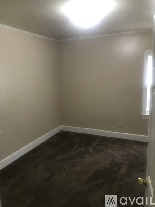 A room with a dark floor and a light on the wall.