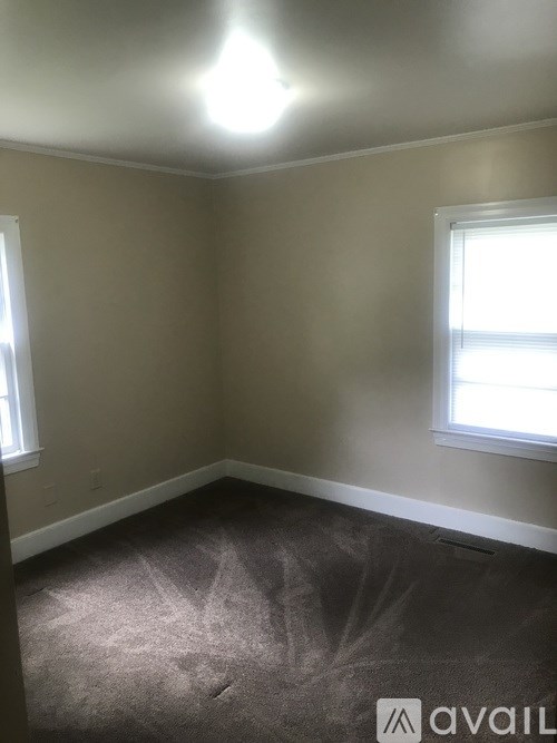 A room with a carpet and a window.