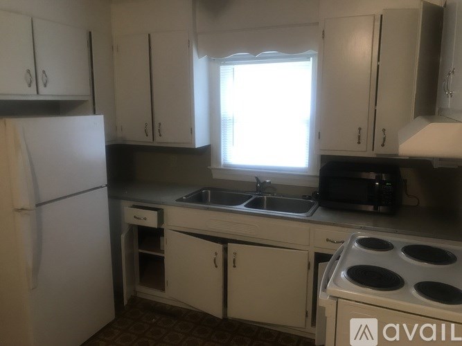 A kitchen with white cabinets and a white fridge.