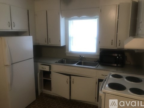 A kitchen with white cabinets and a white fridge.