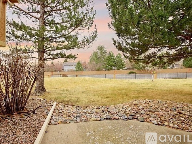 A backyard with a stone pathway and a fence.