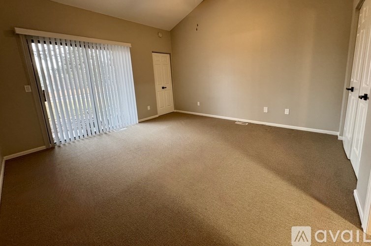 A room with a carpeted floor and a sliding glass door.