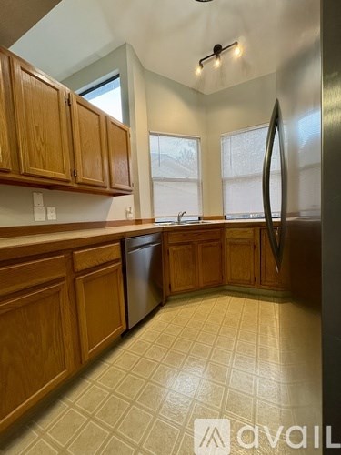 A kitchen with wooden cabinets and a tiled floor.
