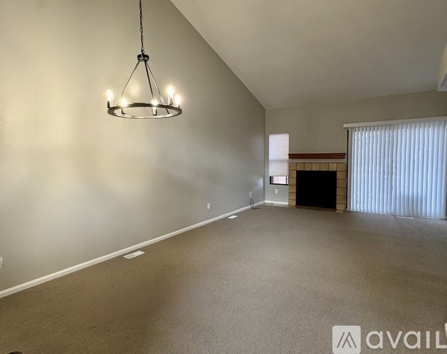 A large, empty room with a chandelier hanging from the ceiling.