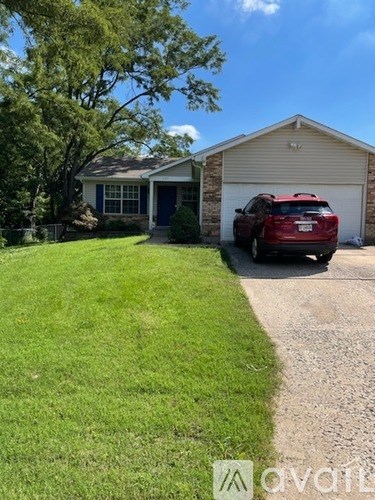 A red car is parked in front of a garage.