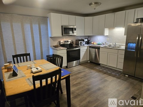 A kitchen with a table set for two and a refrigerator with a water dispenser.