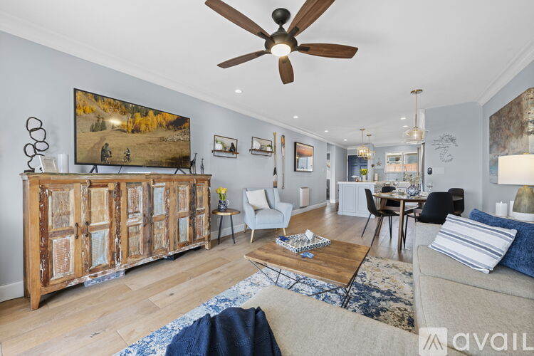 A living room with a large painting on the wall and a wooden cabinet.
