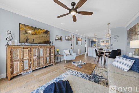 A living room with a large painting on the wall and a wooden cabinet.