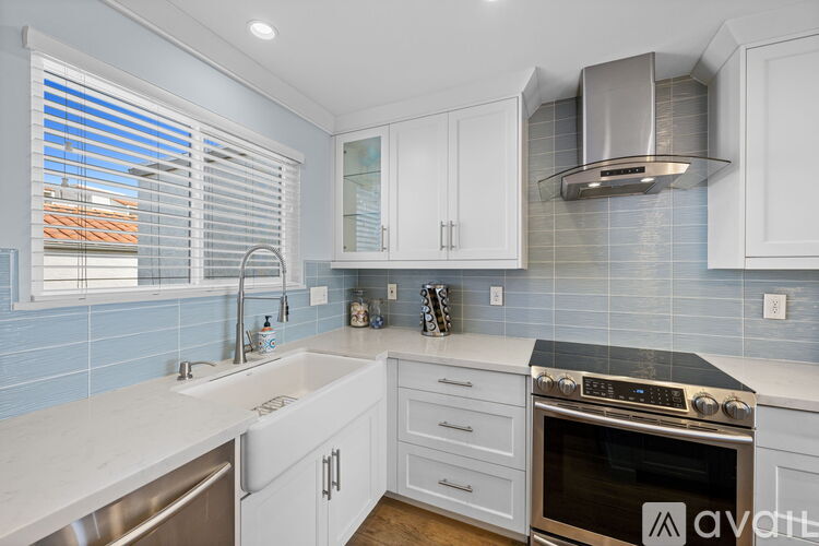 A kitchen with white cabinets and a stainless steel oven.
