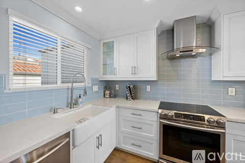 A kitchen with white cabinets and a stainless steel oven.