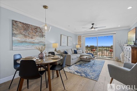 A modern dining room with a table set for two and a view of the balcony.