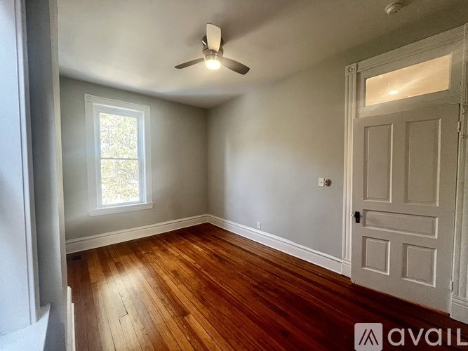 A white doorway leads to a room with wooden flooring.