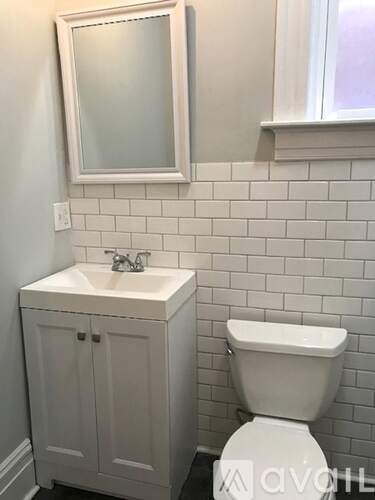 A white toilet sits next to a white sink in a bathroom.