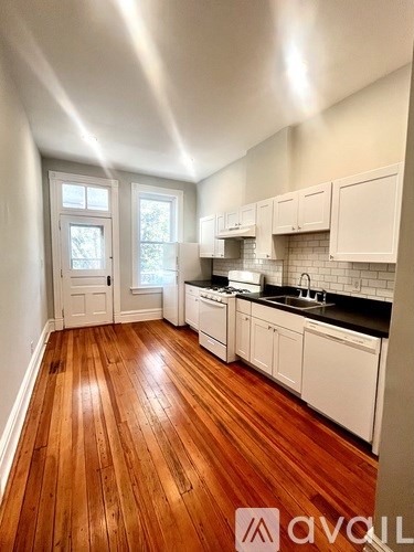 A hallway with a wooden floor and white walls.