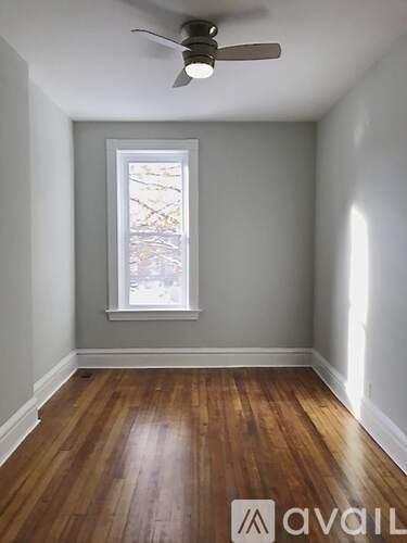 A room with a ceiling fan and a window.