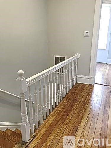 A white railing on a wooden staircase.