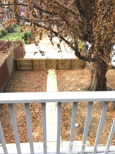 A tree with brown leaves is in the backyard.