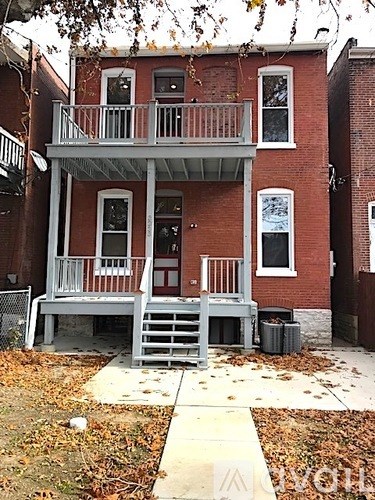 A red brick house with a white porch.
