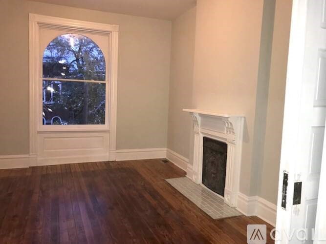 A room with a fireplace and a window.